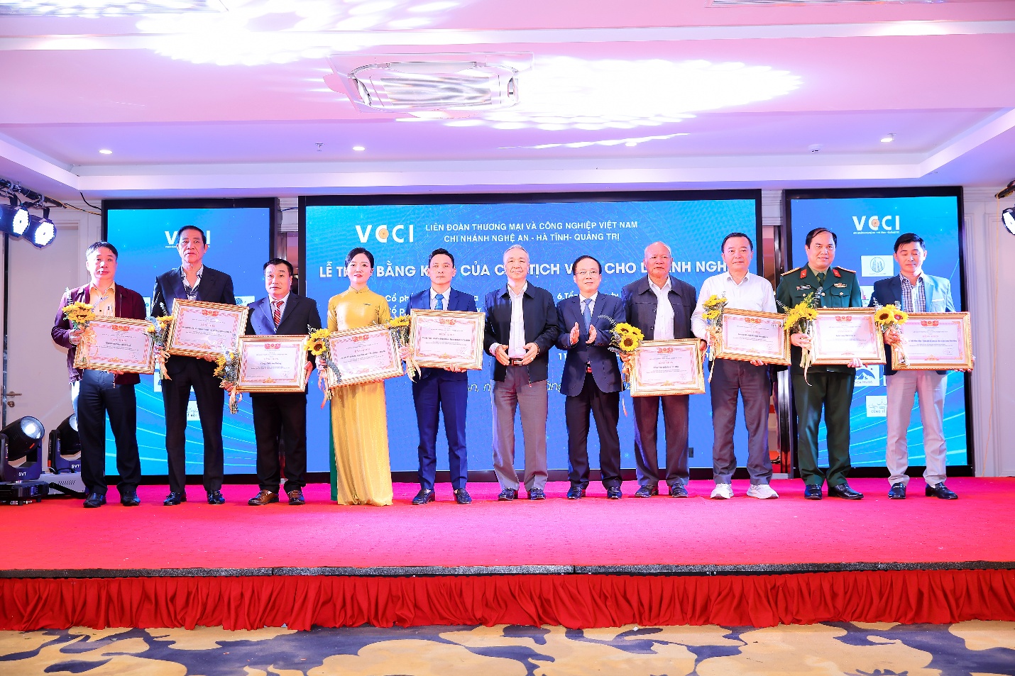 A group of people holding certificatesDescription automatically generated