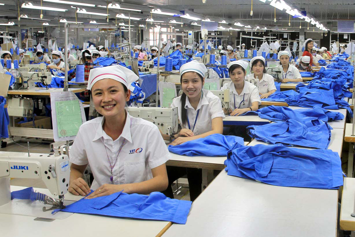 A group of women in a factoryDescription automatically generated